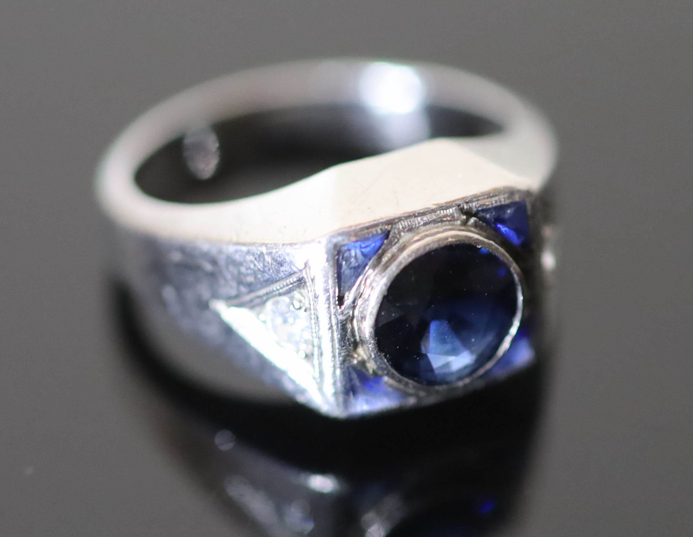 A platinum and single stone synthetic? sapphire set dress ring,